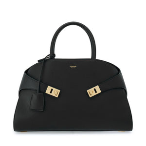 Black handbag with gold hardware on a white background