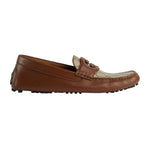 Brown leather loafer with a decorative buckle on a light gray background