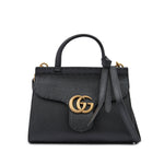 Black handbag with gold logo on a white background