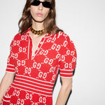 Person wearing a red outfit with a pattern, sunglasses, and a necklace on a white background