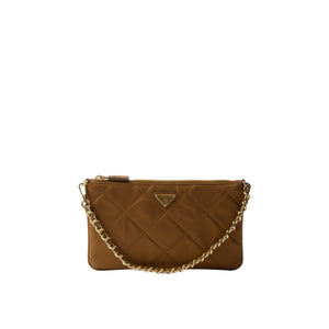 Brown quilted handbag with gold chain on a light gray background