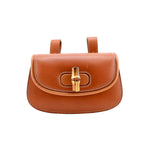 Brown leather handbag with gold clasp on a white background