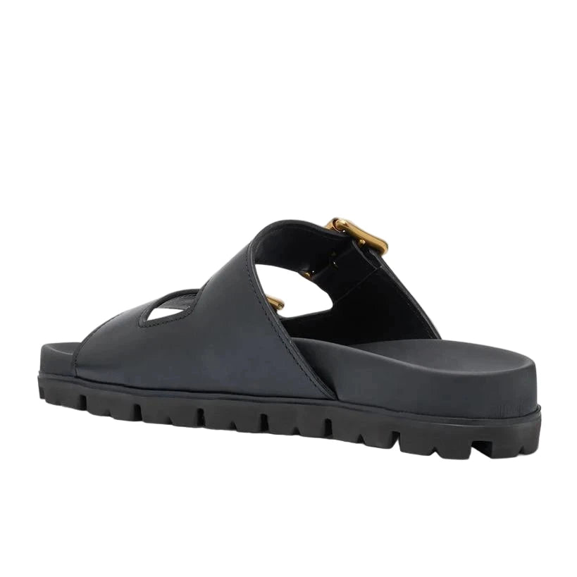 Black sandal with a gold buckle on a white background