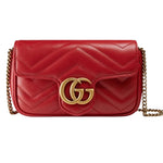 Red quilted handbag with gold chain and Gucci logo on a white background