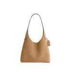 Tan handbag with a price tag on a white background