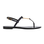Black sandal with gold accents on a white background