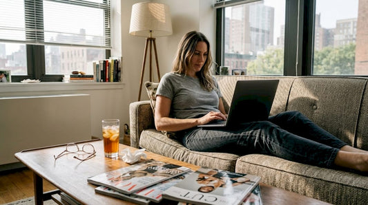 Woman browsing designer deals on laptop at home