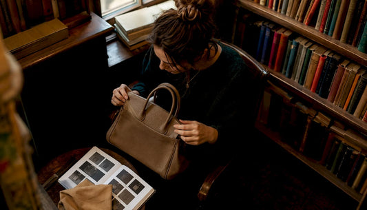 Woman closely examining designer handbag