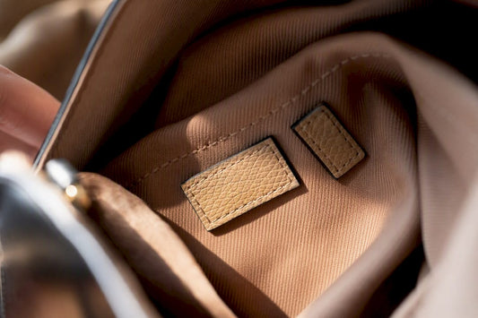 Close-up of handbag serial number on leather tag