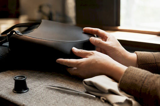 Hands inspecting Chanel bag leather detail