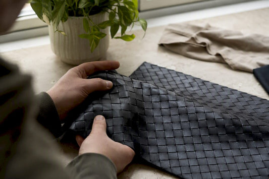 Hands flexing intrecciato leather weave