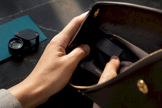 Hands inspecting handbag serial tab