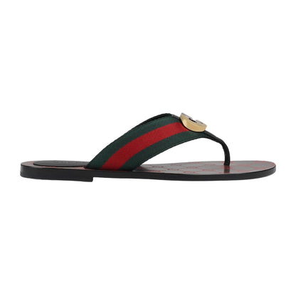 Flip-flop sandal with green and red striped strap on a light gray background