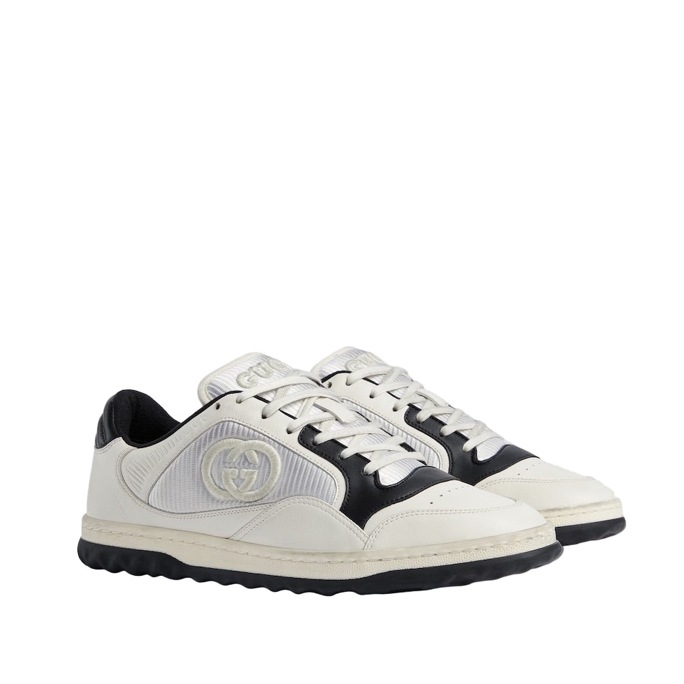 White and black sneakers with a brand logo on a light gray background