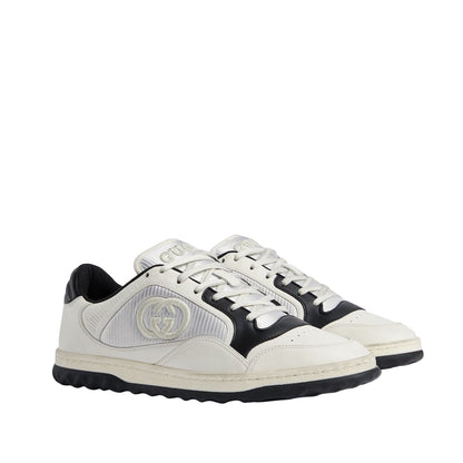 White and black sneakers with a brand logo on a light gray background