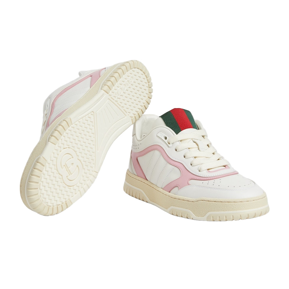 White sneakers with pink accents and a green and red stripe on a light gray background