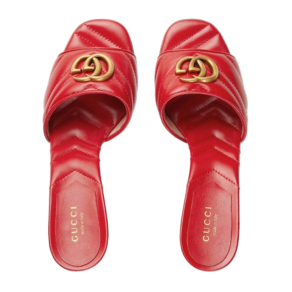 Red Gucci slides with gold logo on a light gray background