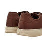 Brown sneakers with beige soles on a light gray background