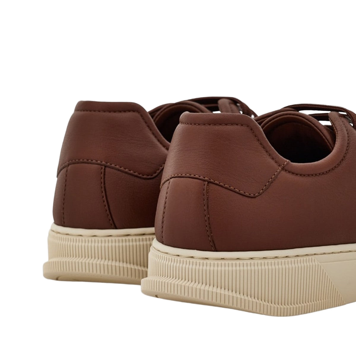 Brown sneakers with beige soles on a light gray background