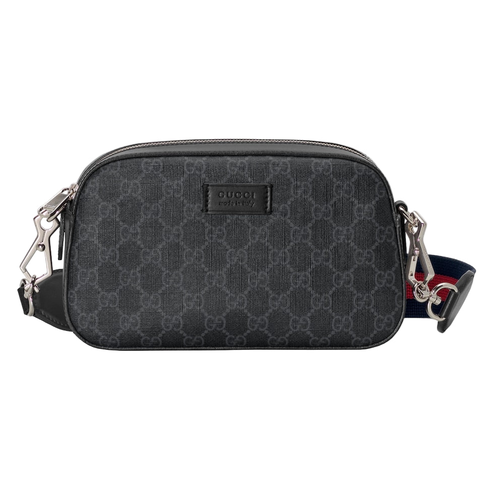 Black patterned Gucci bag with a strap on a light gray background