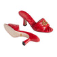 Red high-heeled shoes with Gucci logo on a light gray background
