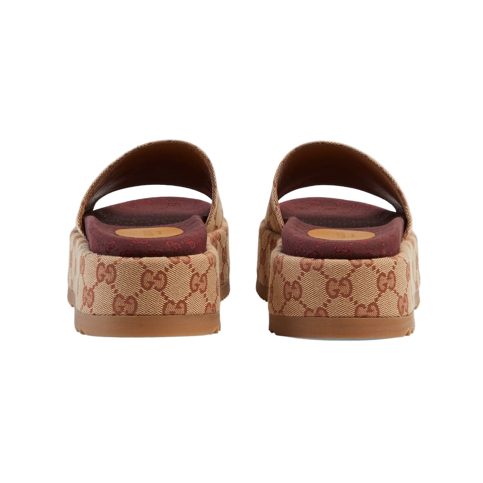 Pair of brown slide sandals with Gucci logo on a light gray background
