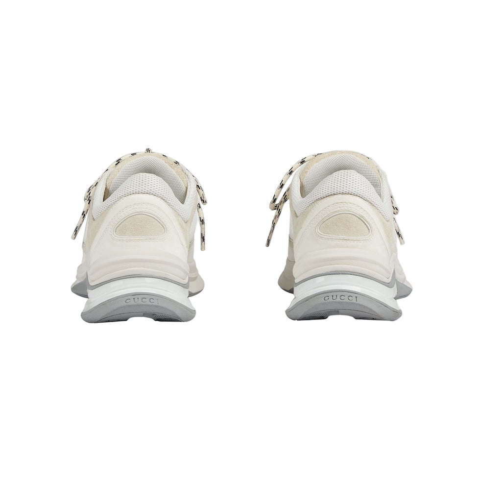 White sneakers with decorative elements on a light gray background