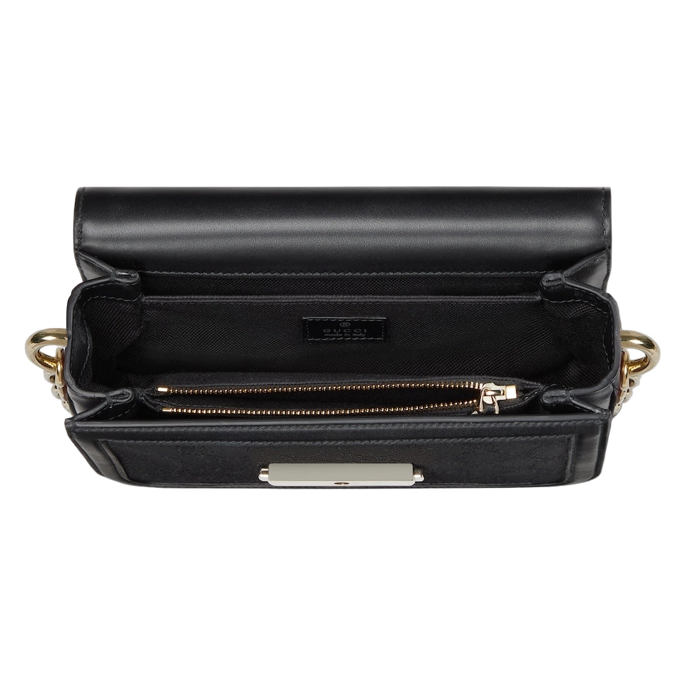 Black handbag with gold accents on a light gray background