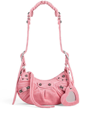 Pink handbag with heart-shaped tag on a white background