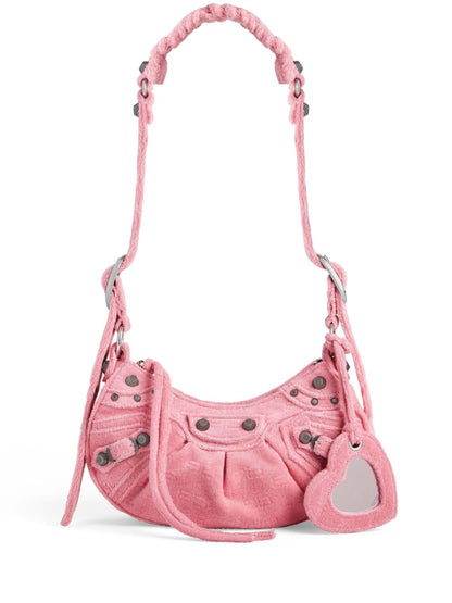 Pink handbag with heart-shaped tag on a white background