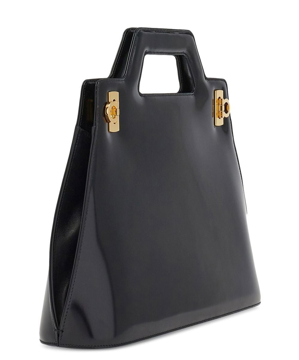Black handbag with gold hardware on a white background
