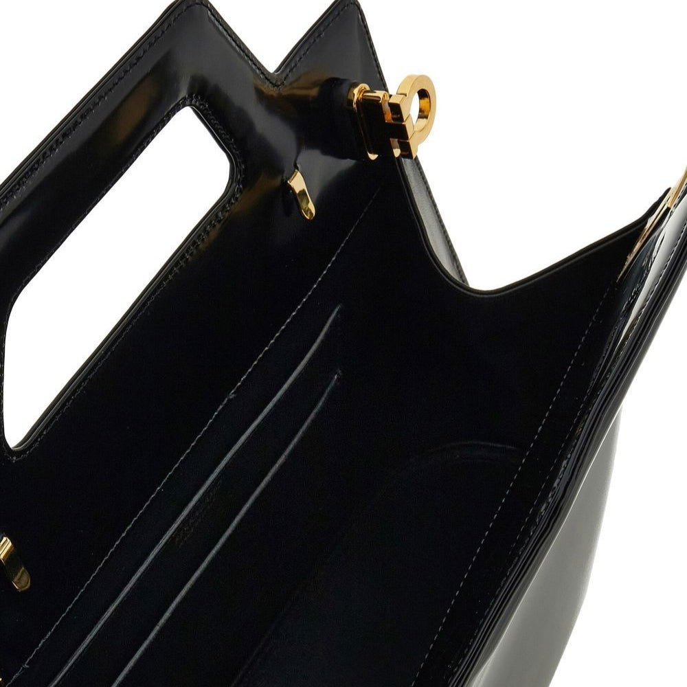 Close-up of a black handbag with gold accents on a white background