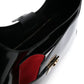 Close-up of a black and red handbag with a gold clasp on a white background