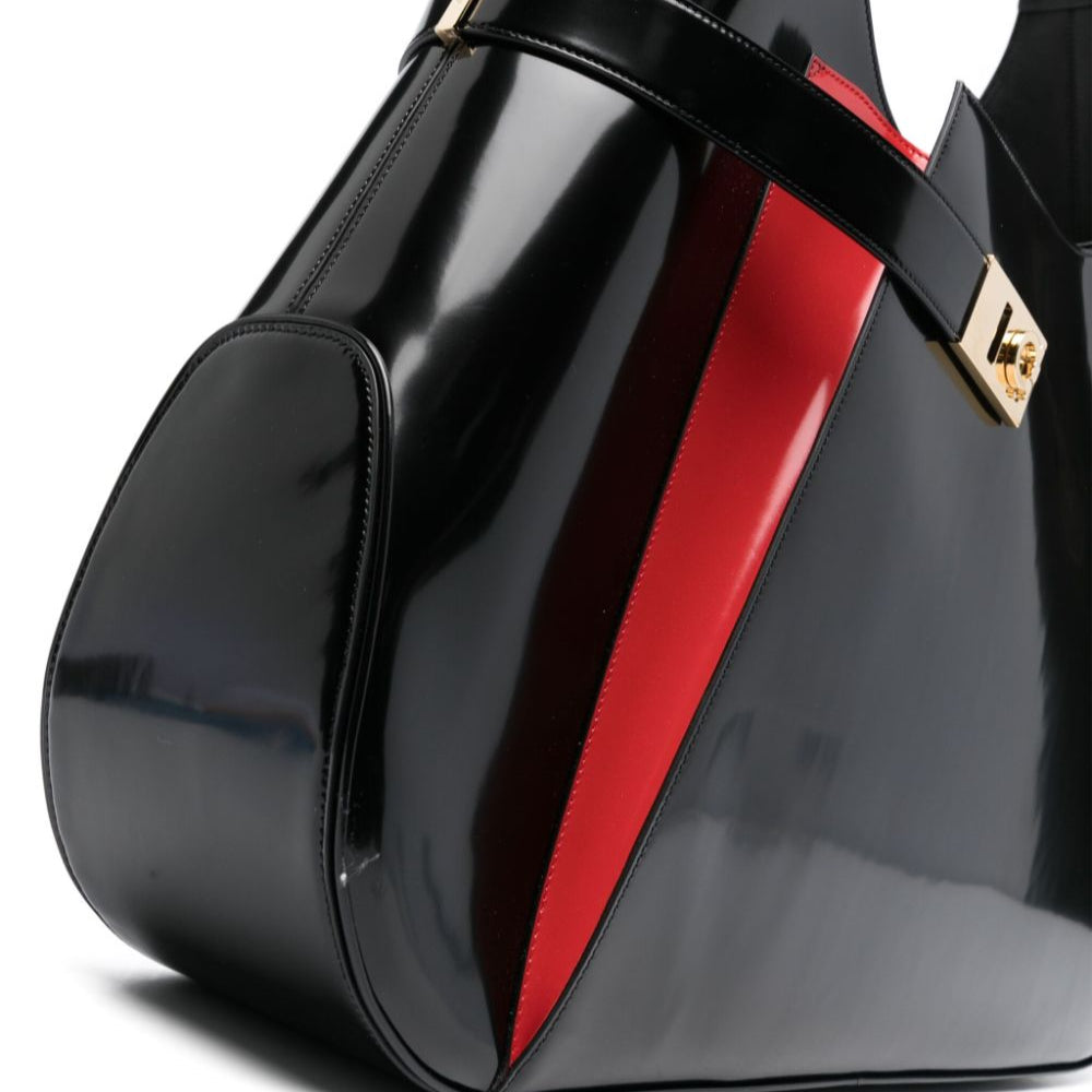 Black glossy handbag with a red stripe on a white background
