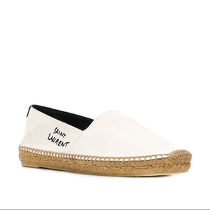 White slip-on shoe with brown sole and 'Saint Laurent' branding on a white background