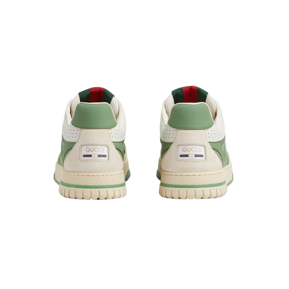 Pair of Gucci sneakers with green and red accents on a light gray background