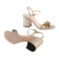 Gold glitter high-heeled sandals with a Gucci logo on a light gray background
