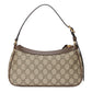 Designer handbag with patterned fabric and gold hardware on a light gray background