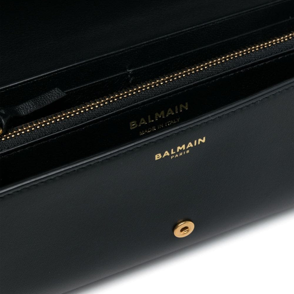 Black handbag with gold zipper and Balmain logo on a white background