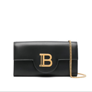 Black handbag with gold chain and logo on a white background