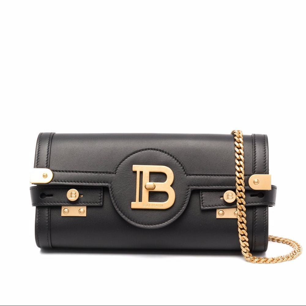 Black handbag with gold chain and logo on a white background