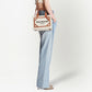 Person holding a Balmain handbag against a white background