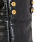 Close-up of a black leather jacket with gold buttons on a white background