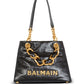 Black handbag with gold chain handle and 'Balmain' branding on a white background