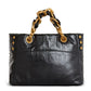 Black handbag with gold chain handle on a white background