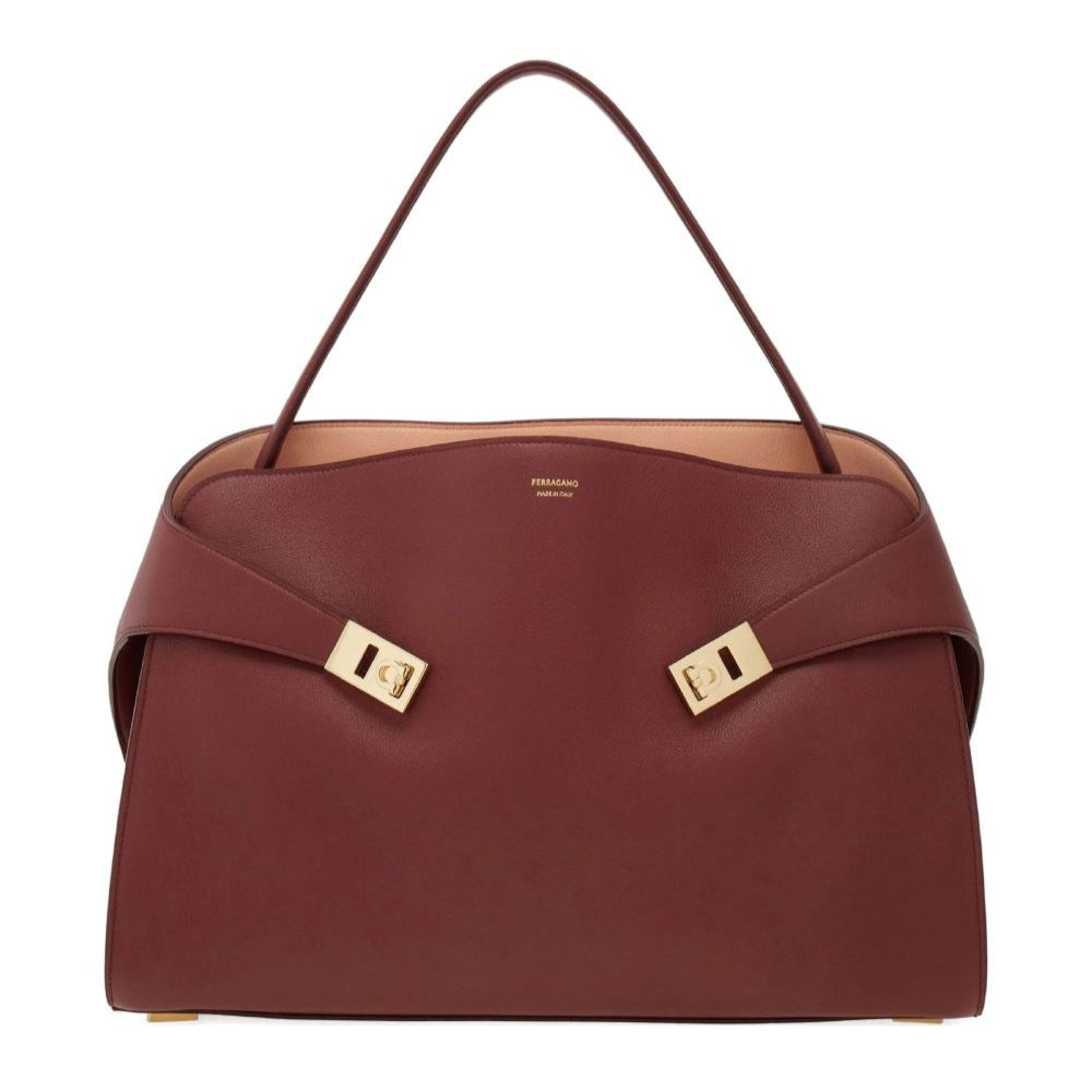 Brown handbag with gold accents on a white background