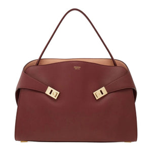 Brown handbag with gold accents on a white background