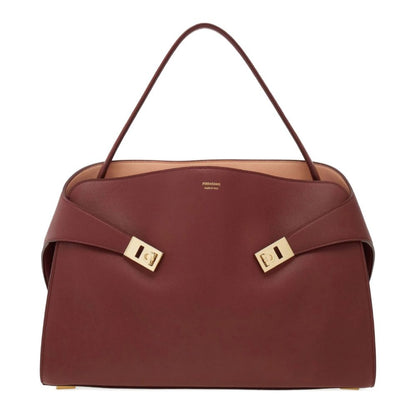 Brown handbag with gold accents on a white background