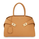 Tan handbag with gold hardware on a white background