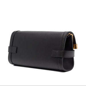 Black leather handbag with gold hardware on a white background
